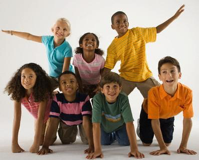 A photo of seven children smiling and forming a small pyramid together