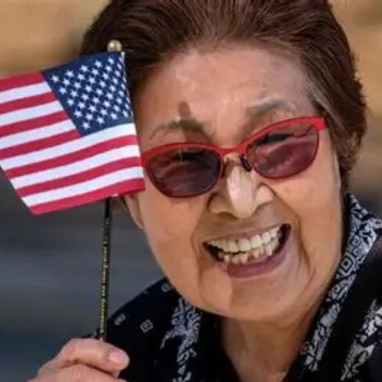 Smiling woman waving small US flag
