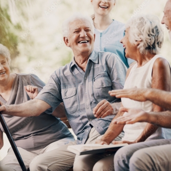 Group of laughing seniors on an outdoor bench