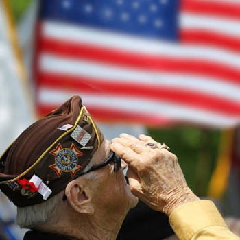Older veteran saluting a US flag